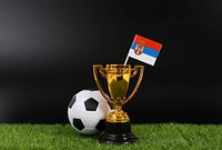 Golden trophy and football ball with flag of Serbia 