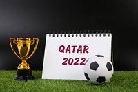 Golden trophy and notebook with Qatar 2022 text 