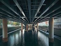 Canal Under a Freeway, Tokyo, JapanThe green water of an aging canal runs under an elevated expressway and shows striped reflections in Kanda, Chiyoda City, Tokyo, Japan.