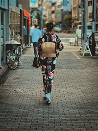 Woman Wearing Kimono, Tokyo, JapanA Japanese woman wearing a traditional garment (kimono) walking on a sidewalk, Nezu, Bunkyo City, Tokyo, Japan.