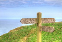 Signpost, hilltop coastline field landscape.