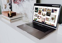 Laptop displaying images on a blog on a white table
