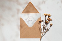 White card in a brown envelope with dried flowers mockup