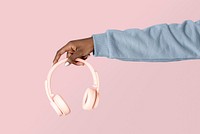 Hand holding pink headphones