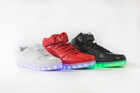 Three shoes with LED lights on the sole, one red, one white, and one black.