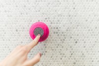 Pink waterproof speaker on wall.