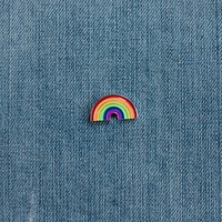 Rainbow enamel pin on denim.
