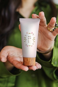 Woman holding lotion with both hands mockup