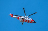 Rescue helicopter flying over Sidmouth Beach.