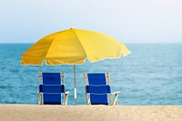 Blue beach chairs with yellow umbrella