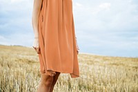 Woman with brown dress standing in grass field