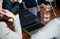 Business people using a laptop screen mockup in a meeting