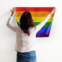 Pride flag background, woman decorating wall