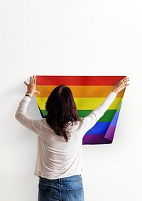 Pride flag background, woman decorating wall