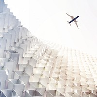 Flying plane over white building