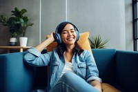 Asian woman enjoy music on a couch