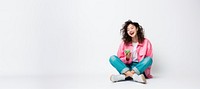 Asian woman using phone, sitting on a floor.