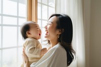 Asian baby sleeping on mom's chest