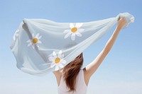 Woman holding white scarf, rear view