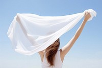 Woman holding white scarf, rear view. 