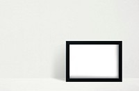 Black frame mockup against a white wall