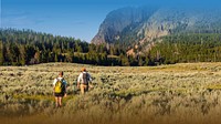 Mountain landscape desktop wallpaper, travelers walking through grass