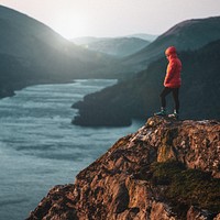 Man standing cliff background, nature travel image