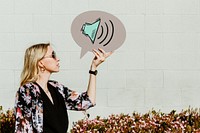 Woman holding volume speech bubble sign