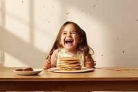 Pancake eating table happy. AI generated Image by rawpixel.