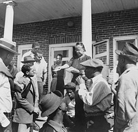 Daytona Beach, Florida. Bethune-Cookman College. Mrs. Shaw handing out mail to college and NYA (National Youth Administration) students in front of the boys' dormitory. Sourced from the Library of Congress.