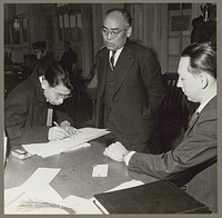 San Francisco, Calif. Apr. 1942. A father and son registering for the evacuation of persons of Japanese ancestry. The evacuees will be housed in War Relocation Authority centers for the duration of the war. Sourced from the Library of Congress.