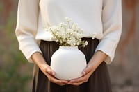 White flower vase  holding adult. AI generated Image by rawpixel.