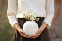 White flower vase holding adult. 