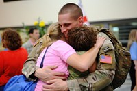 Soldier hugging family child. 