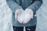 Snow outdoors holding glove. 