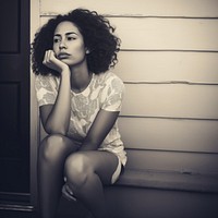 Authentic photo of mixed race woman is sitting and contemplating something.  