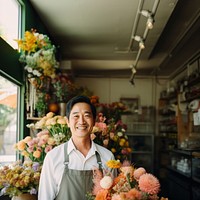 photo of local flower shop and asian man happy owner in front. 