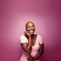 close up face photo of a bald chubby black woman smiling with pink tone makeup.  