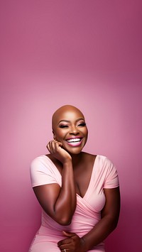 close up face photo of a bald chubby black woman smiling with pink tone makeup.  