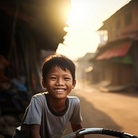 Cambodian boy outdoors bicycle smiling. 