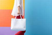 Woman hauling a white tote bag handbag studio shot accessories. 