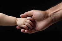 Dad hand hold baby hand finger togetherness touching. 