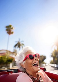 Eldery woman driving laughing glasses car. 