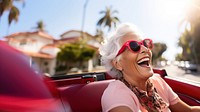 Eldery woman driving laughing outdoors glasses. 