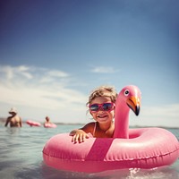 Pink flamingo inflatable sunglasses swimming. 