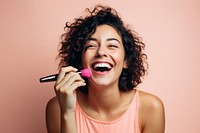 Woman applying mascara laughing happy microphone. 