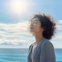 photo of woman praying with bluesky on the sea with blurred vision. AI generated Image by rawpixel. 