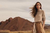 A woman standing wearing a minimal colorful outfit outdoors nature desert. 