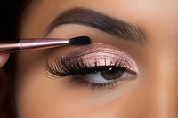 Woman applying eyeshadow cosmetics adult brush. 