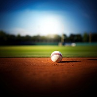 photo of Close-up of baseball on Grass Field with Blurry Stadium in Background. 